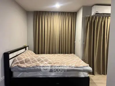 Cozy bedroom with modern decor and air conditioning, featuring elegant curtains and a comfortable bed.