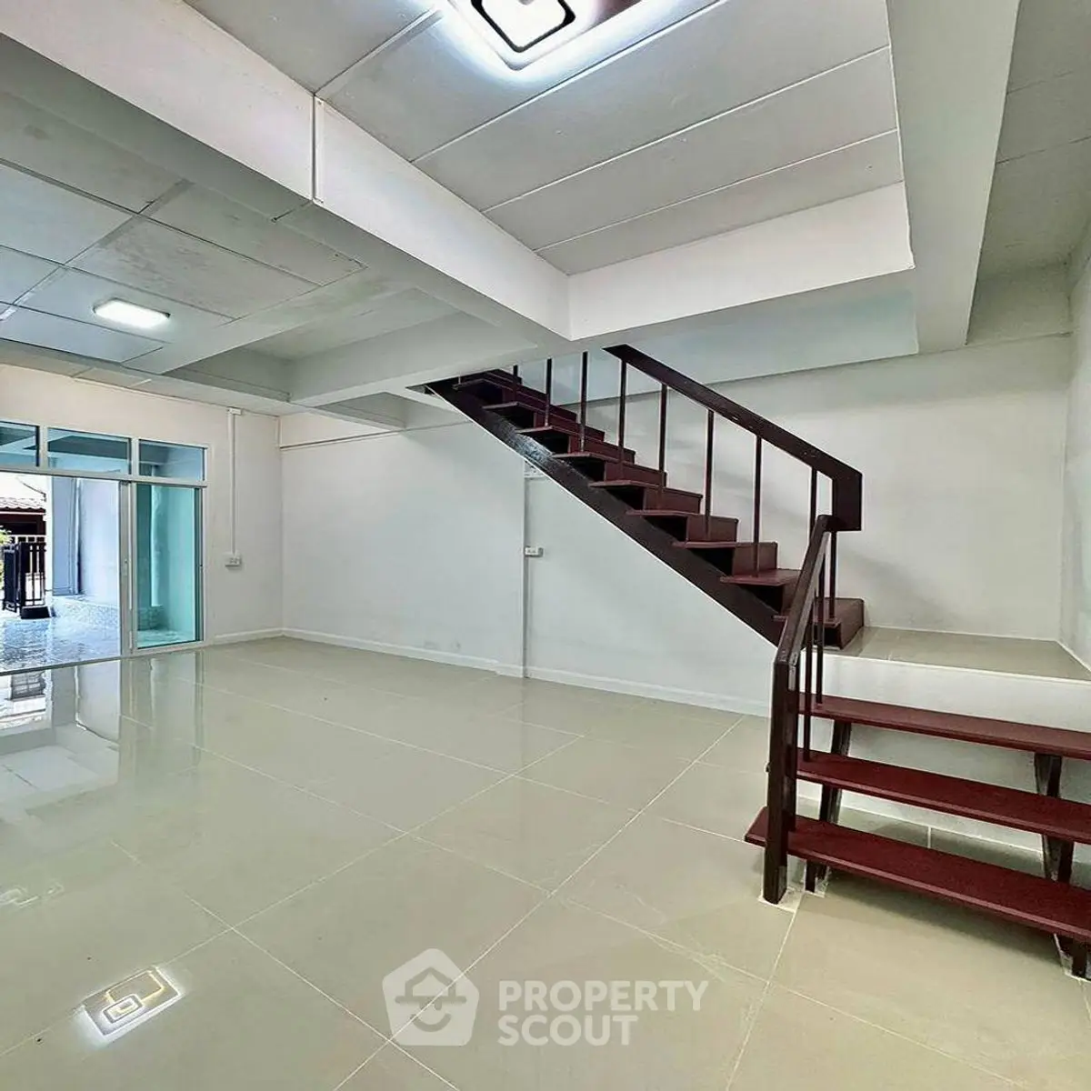 Spacious modern interior with sleek staircase and glossy tiled flooring, perfect for contemporary living.