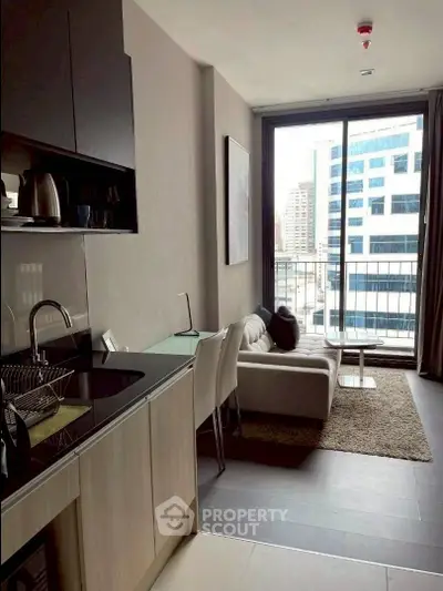 Modern apartment with sleek kitchen and cozy living area featuring large windows and city view.