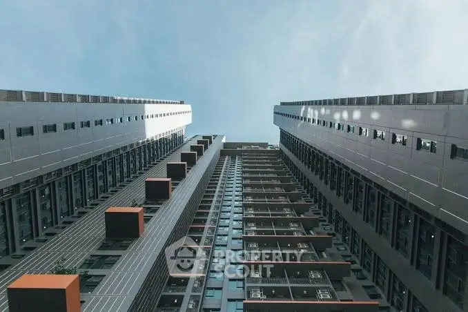 Stunning architectural view of modern high-rise building with sleek design and sky backdrop.