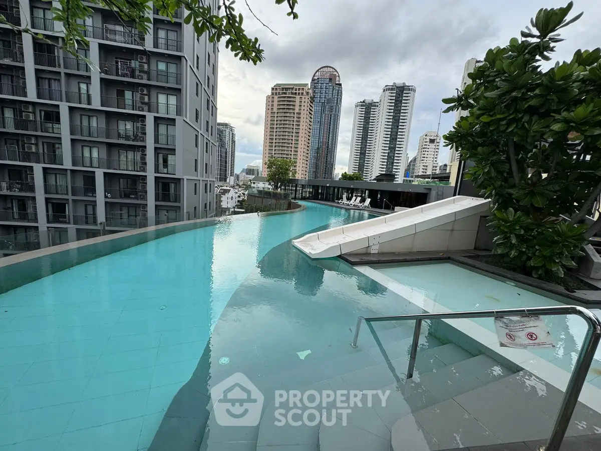 Luxurious rooftop pool with city skyline view in modern high-rise building.