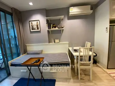 Cozy studio apartment with modern decor, featuring a daybed, desk, and air conditioning.
