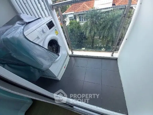 Compact balcony with washing machine and city view