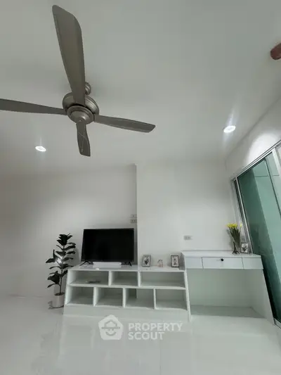 Modern minimalist living room with ceiling fan and sleek TV unit