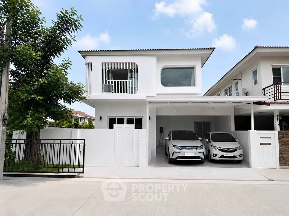 Modern two-story white house with carport and sleek design in a suburban neighborhood.