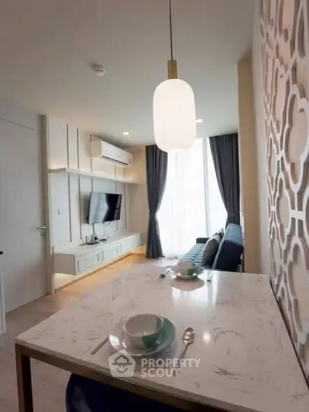 Modern living room with stylish decor and dining area in a cozy apartment.