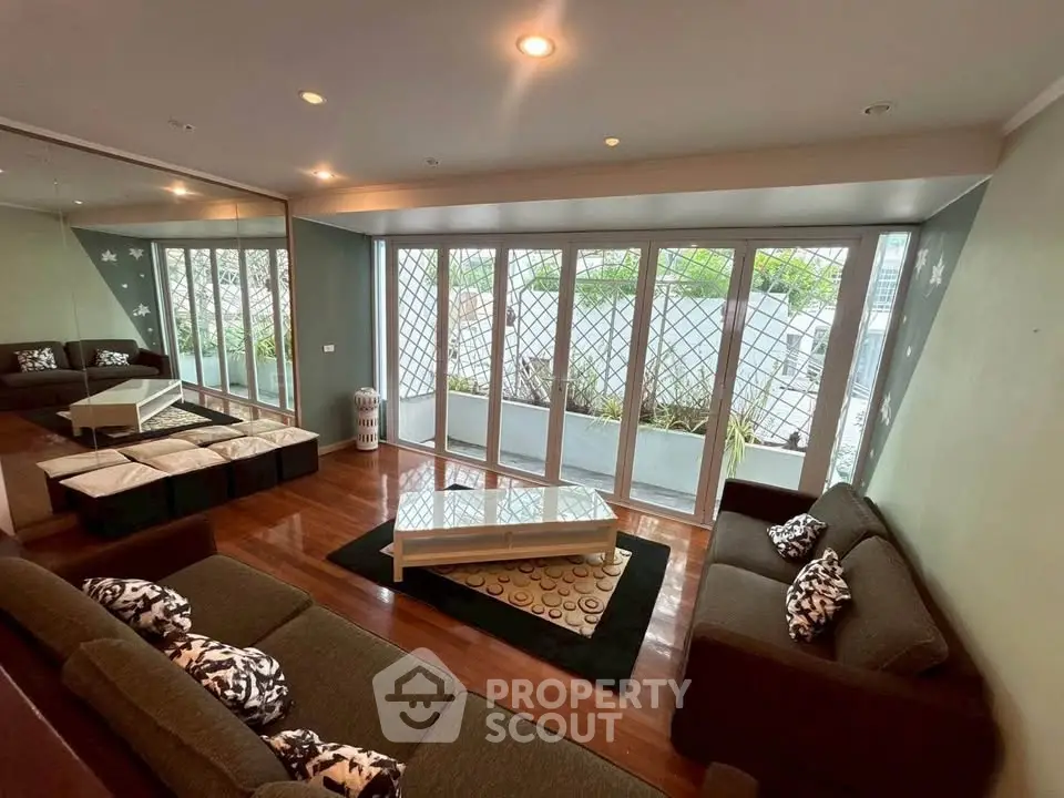 Spacious living room with large windows and stylish decor, offering a cozy and inviting atmosphere.