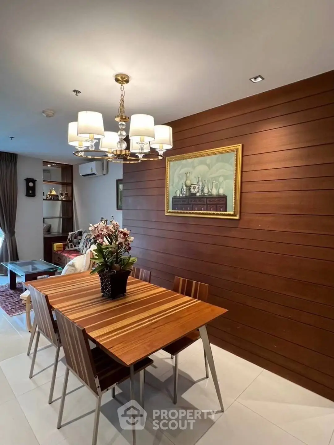 Elegant dining area with wooden accents and modern chandelier in a cozy apartment.