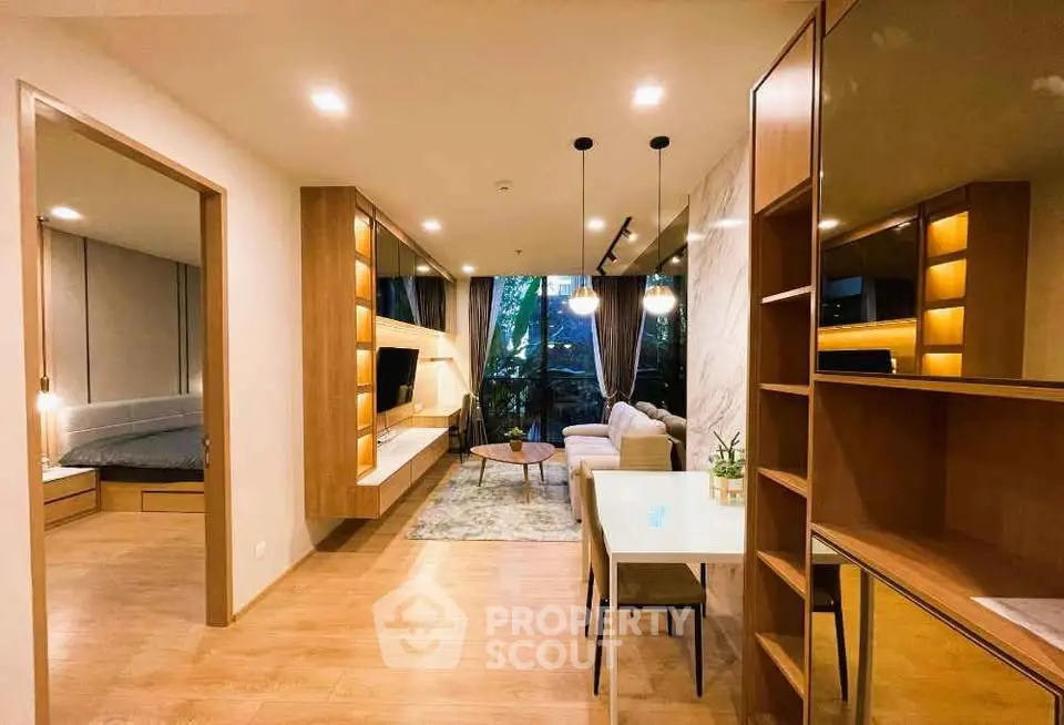 Modern living room with stylish decor and open layout, featuring cozy seating and elegant lighting.