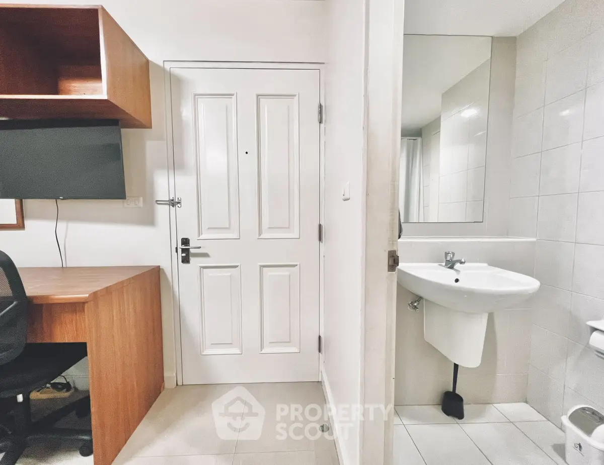 Compact study area with desk and adjacent bathroom in modern apartment