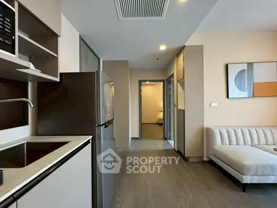 Modern apartment interior with sleek kitchen and cozy living area, featuring contemporary decor and ample natural light.