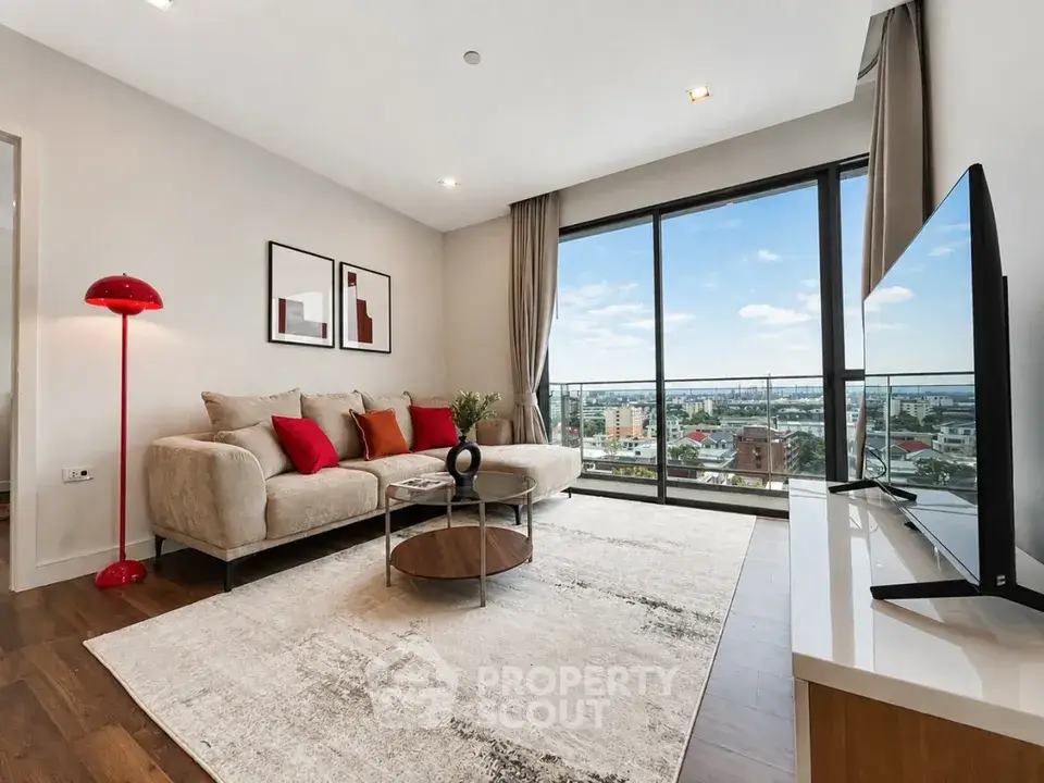 Modern living room with large windows offering stunning city views and stylish decor.