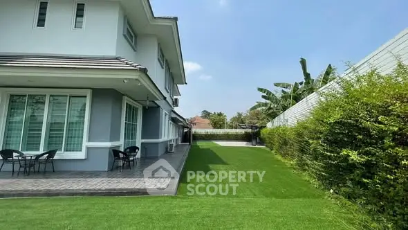 Spacious modern home with lush green lawn and patio area, perfect for outdoor relaxation.