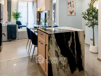 Luxurious open-plan kitchen and living area with elegant marble island and stylish decor.