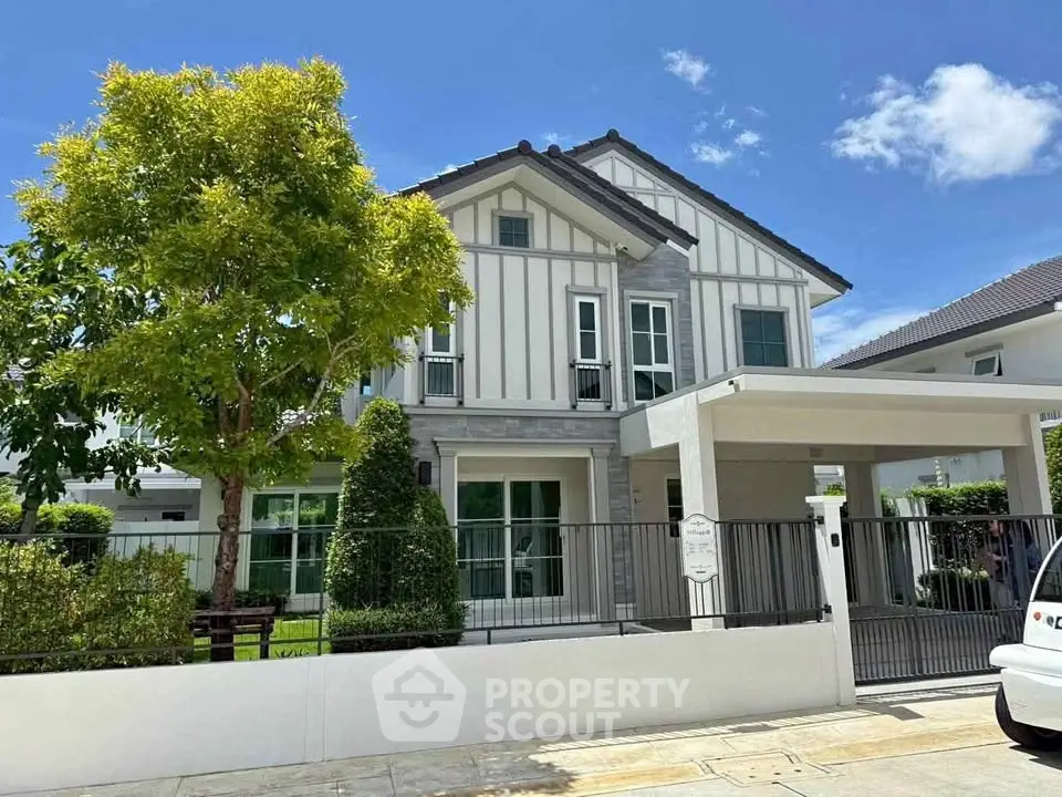 Charming two-story house with modern design and lush garden, perfect for family living.