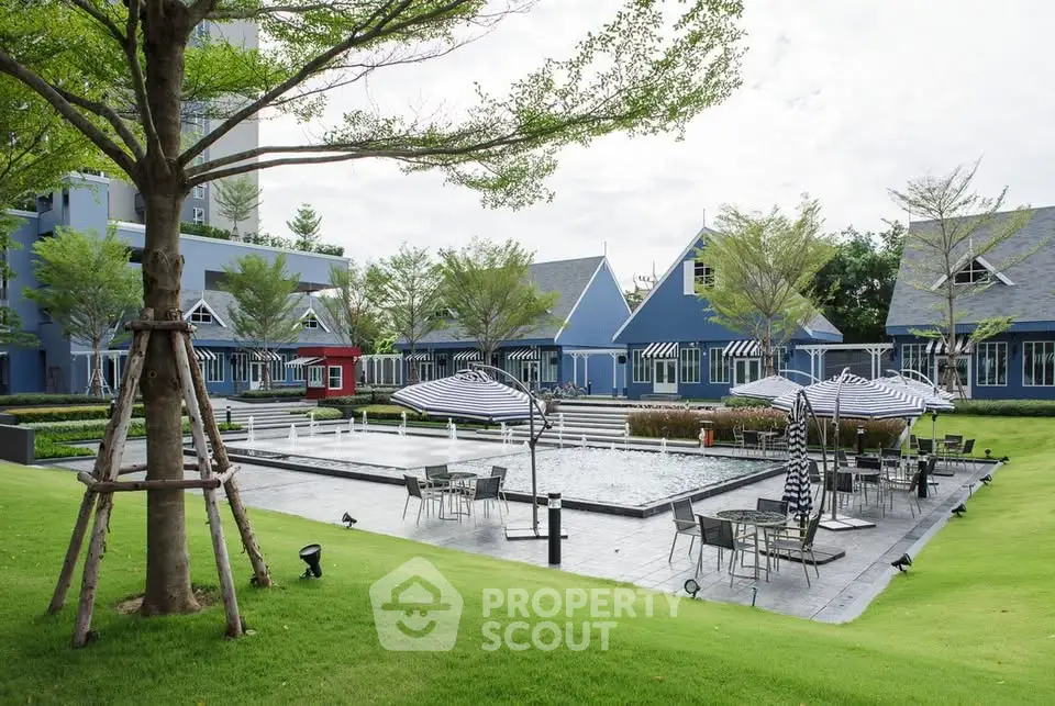 Charming residential complex with poolside seating and lush greenery