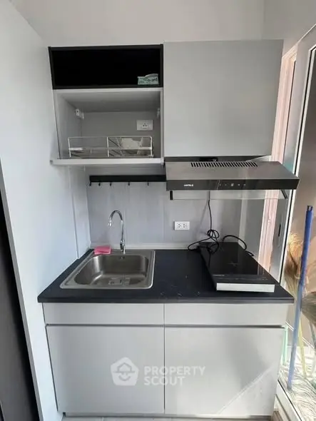 Compact modern kitchen with sleek cabinetry and electric stove