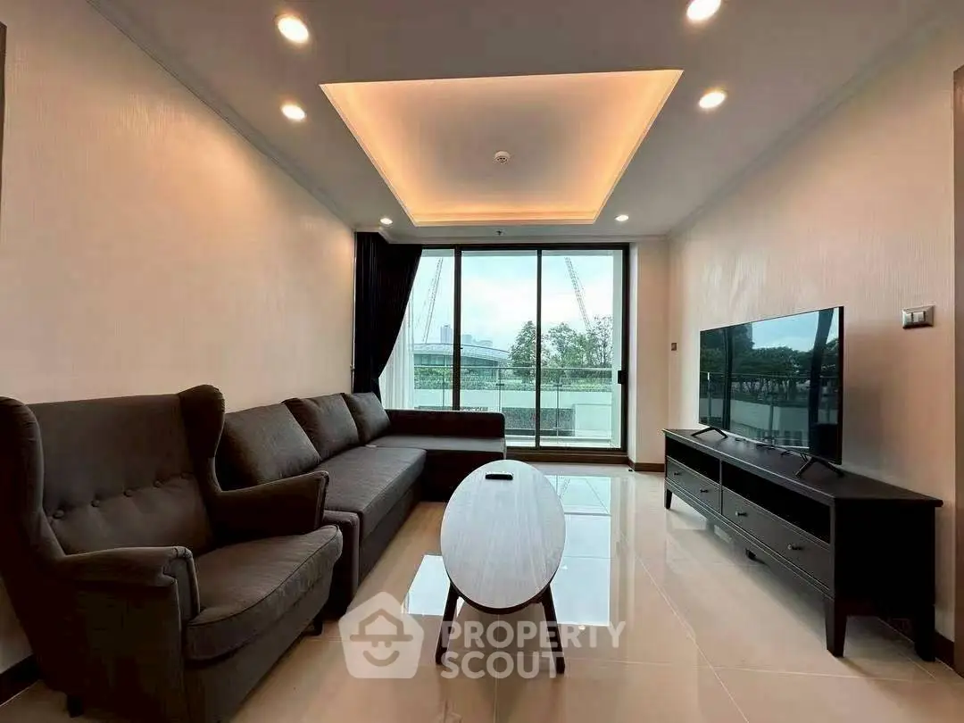 Spacious modern living room with elegant furniture and large windows offering natural light.