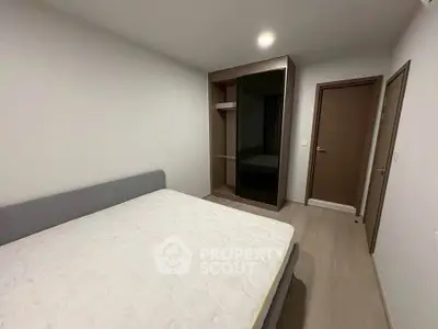 Modern bedroom with sleek wardrobe and comfortable bed in minimalist design.