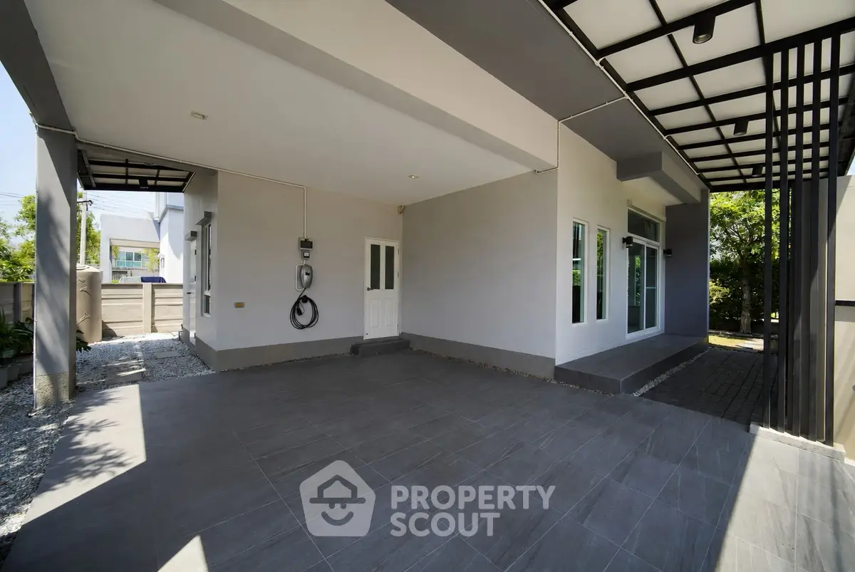Modern house exterior with spacious covered parking area and sleek design.
