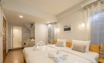 Cozy twin bedroom with modern decor and ensuite bathroom in a stylish apartment.