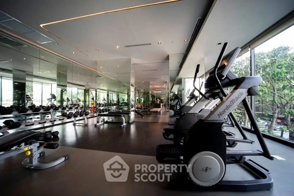 Luxurious gym with modern equipment and panoramic windows in upscale real estate property.