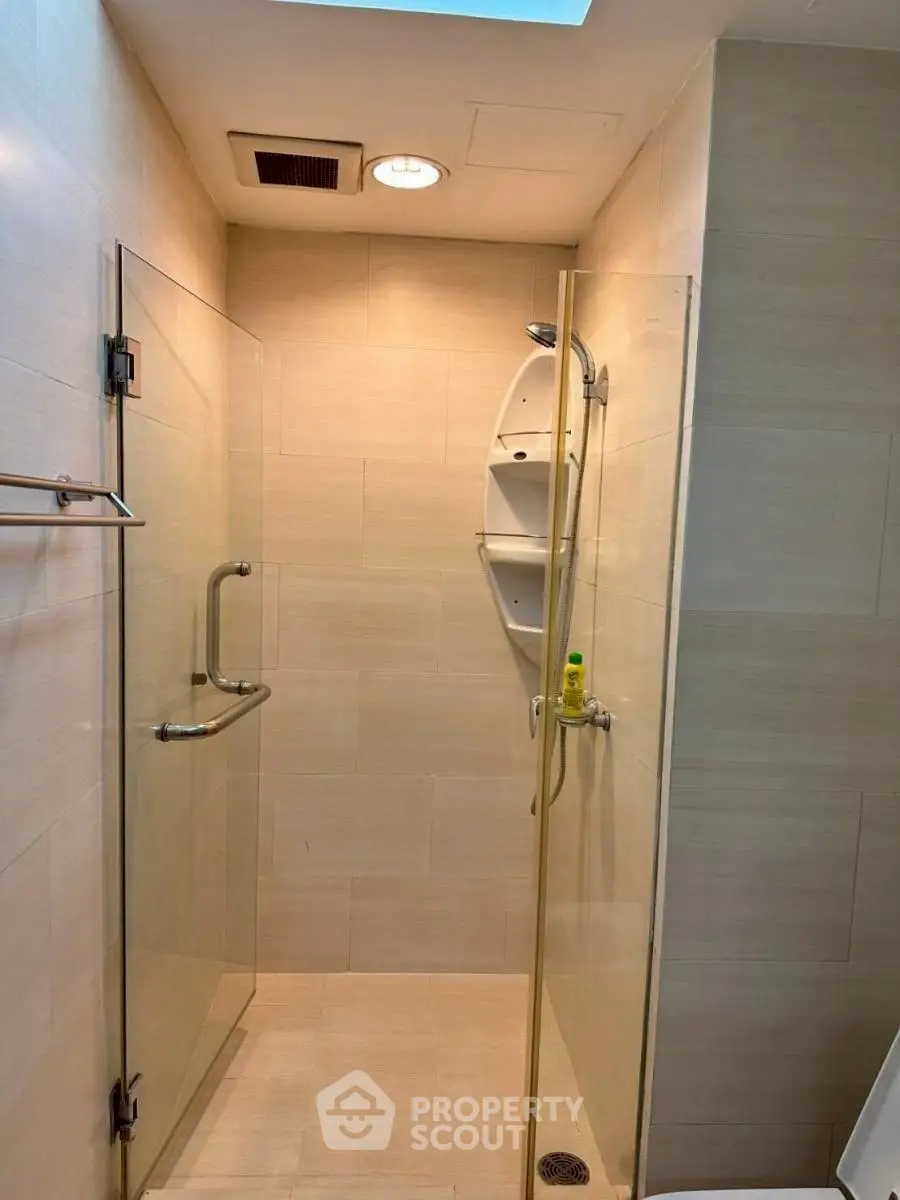 Modern bathroom with glass shower enclosure and sleek fixtures