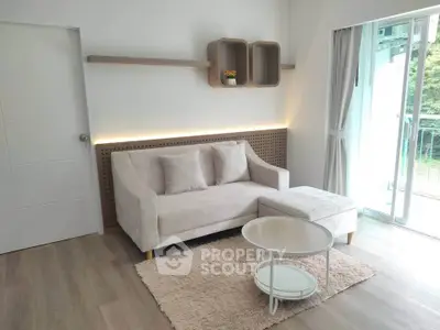 Modern living room with cozy sofa, stylish decor, and balcony view in a bright apartment.