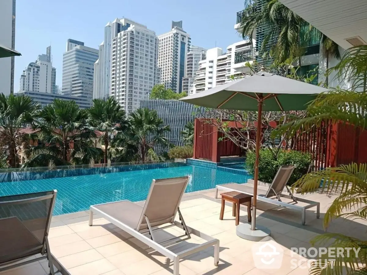 Luxurious rooftop pool with city skyline view and sun loungers in modern urban setting.