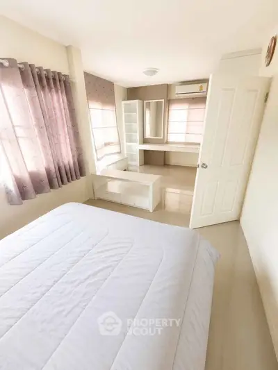 Bright and airy bedroom with modern furnishings and large windows in a stylish home.