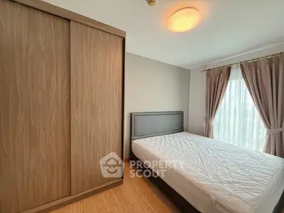 Cozy bedroom with wooden wardrobe and large window for natural light