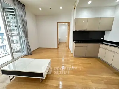 Modern open-layout living room with sleek kitchen and balcony access