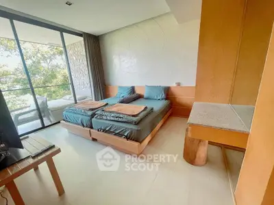Spacious bedroom with twin beds and large windows offering a serene view of nature.