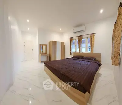 Spacious bedroom with modern design, featuring a large bed, wardrobe, and elegant curtains.