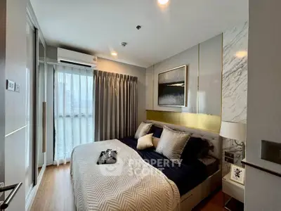 Modern bedroom with stylish decor and natural light, featuring a cozy bed and elegant furnishings.