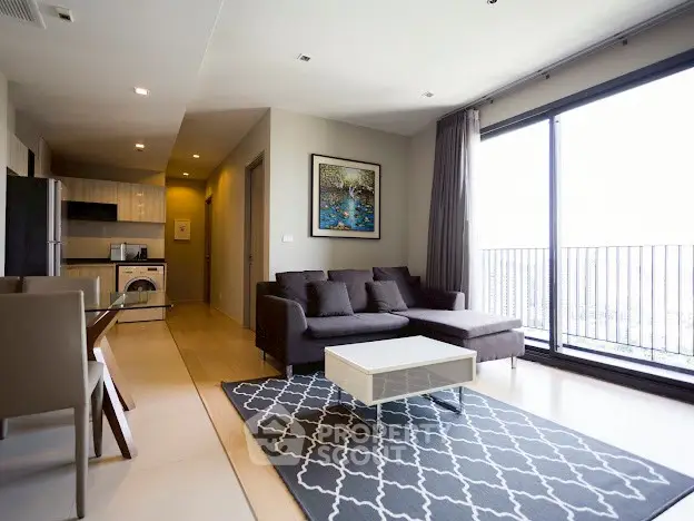 Modern living room with large windows and stylish furniture in a high-rise apartment.