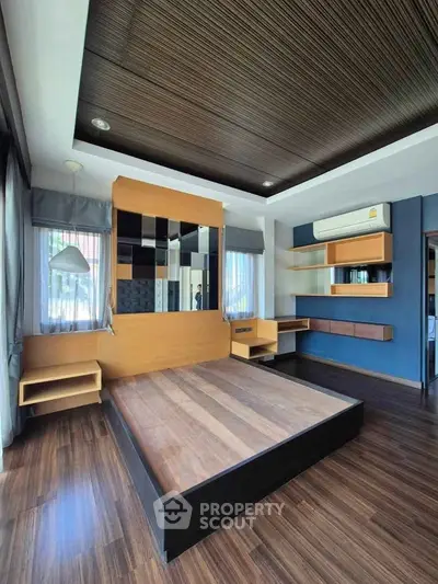 Spacious modern bedroom with wooden flooring and stylish ceiling design