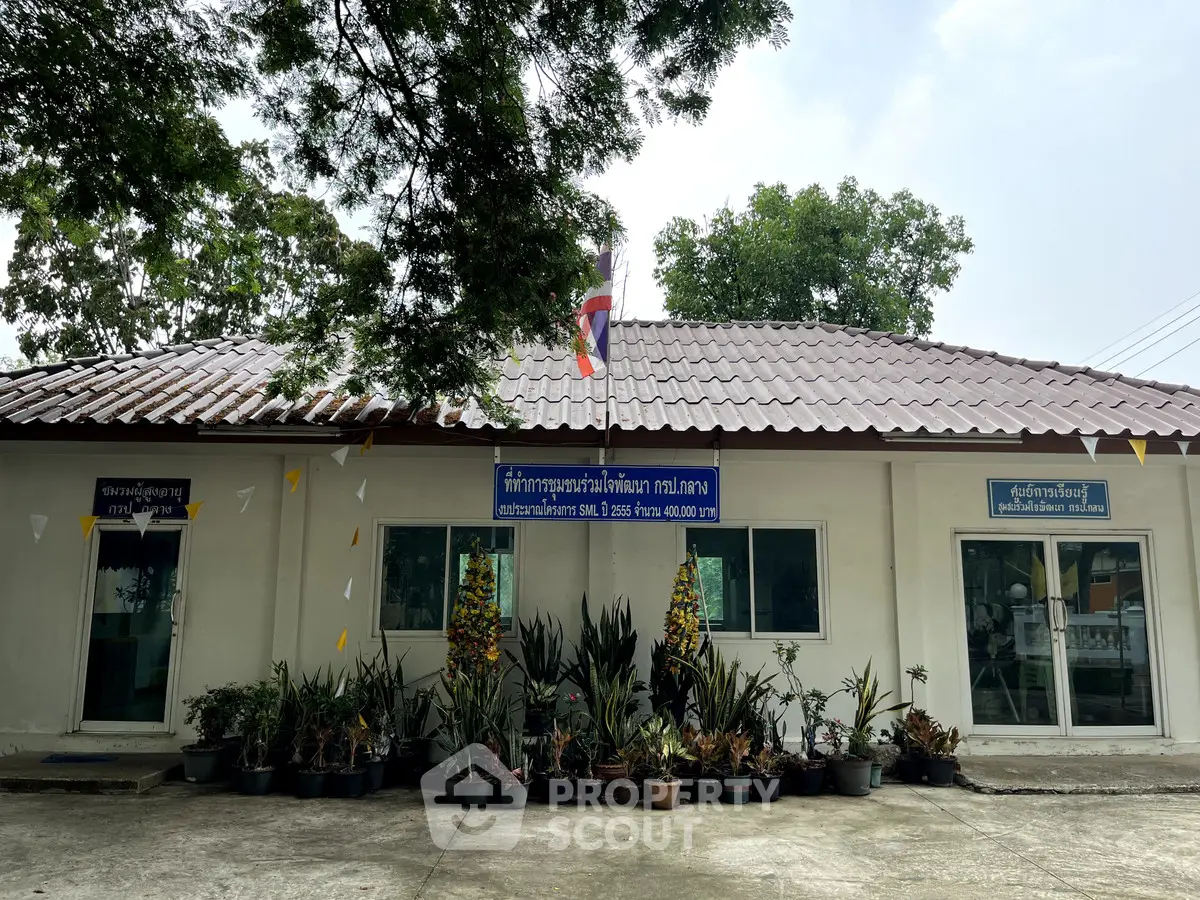 Charming single-story building with lush potted plants and a welcoming entrance, ideal for small business or community use.