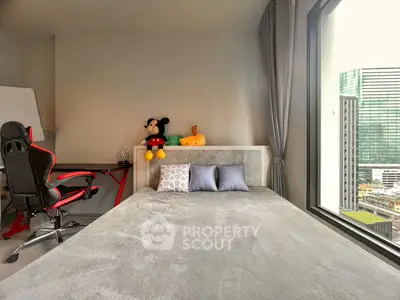 Modern bedroom with large window and city view, featuring a stylish desk and comfortable bed.