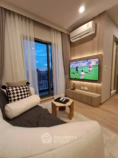Modern living room with balcony view, cozy seating, and wall-mounted TV in stylish apartment.