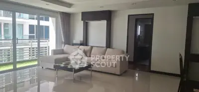 Spacious modern living room with large windows and elegant furnishings in a high-rise apartment.