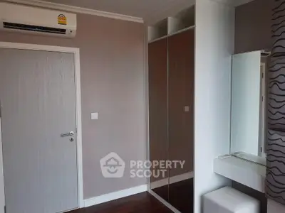 Modern bedroom with mirrored wardrobe and air conditioning unit
