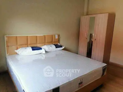 Spacious bedroom with modern bed and wardrobe, perfect for comfort and style.