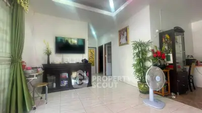 Spacious living room with modern decor and natural light, featuring a TV and elegant furnishings.