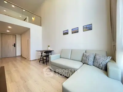 Modern living room with high ceiling and stylish decor in a contemporary apartment.