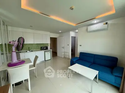 Modern open-plan living room with sleek kitchen and vibrant blue sofa, perfect for contemporary living.