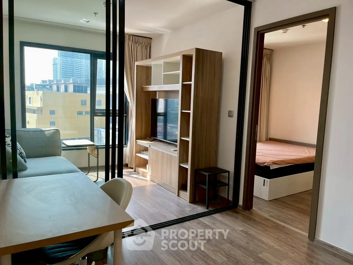 Modern apartment with open living area and cozy bedroom, featuring stylish furnishings and natural light.