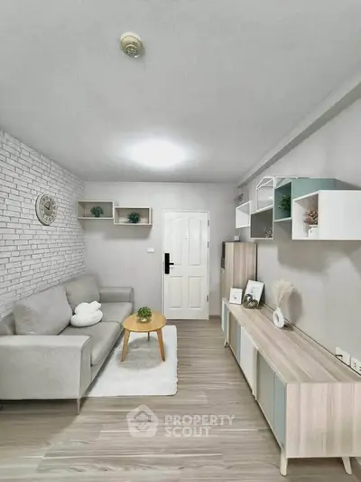 Modern living room with stylish decor and neutral tones, featuring a cozy sofa and sleek storage solutions.