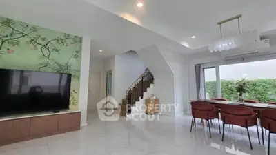 Spacious modern living room with elegant dining area and stylish staircase, perfect for family gatherings.