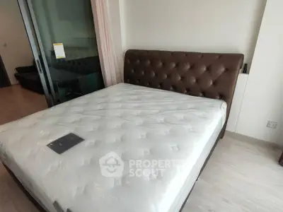 Spacious bedroom with modern bed and glass sliding doors in a stylish apartment